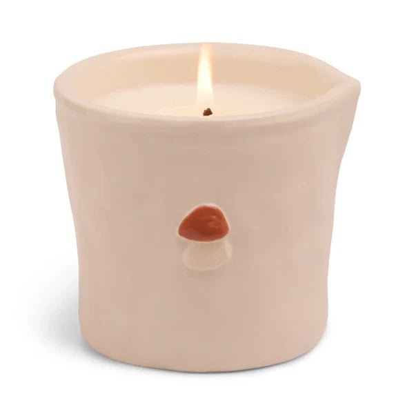 Beige candle with a mushroom design on a white background