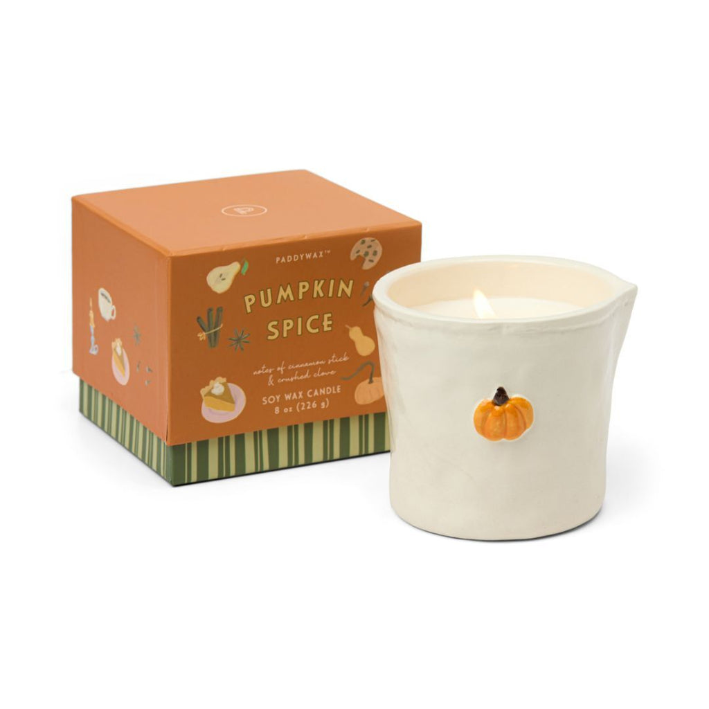 Pumpkin spice candle with decorative packaging on a white background